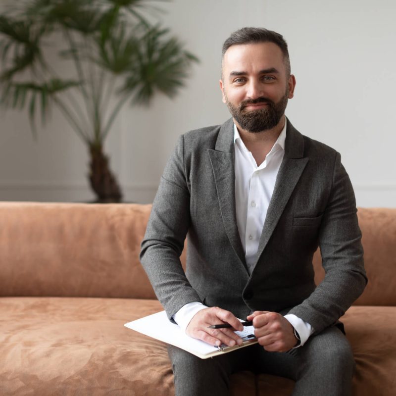 portrait-of-confident-male-therapist-in-suit-sitti-YNKQ6R6.jpg